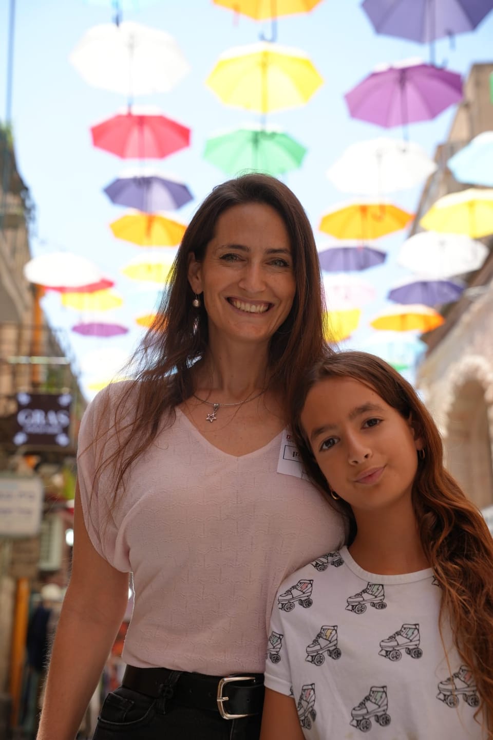 אמא ובת מחובקות ברחוב המטריות בירושלים, ביום השיא של תוכנית בת המצווה